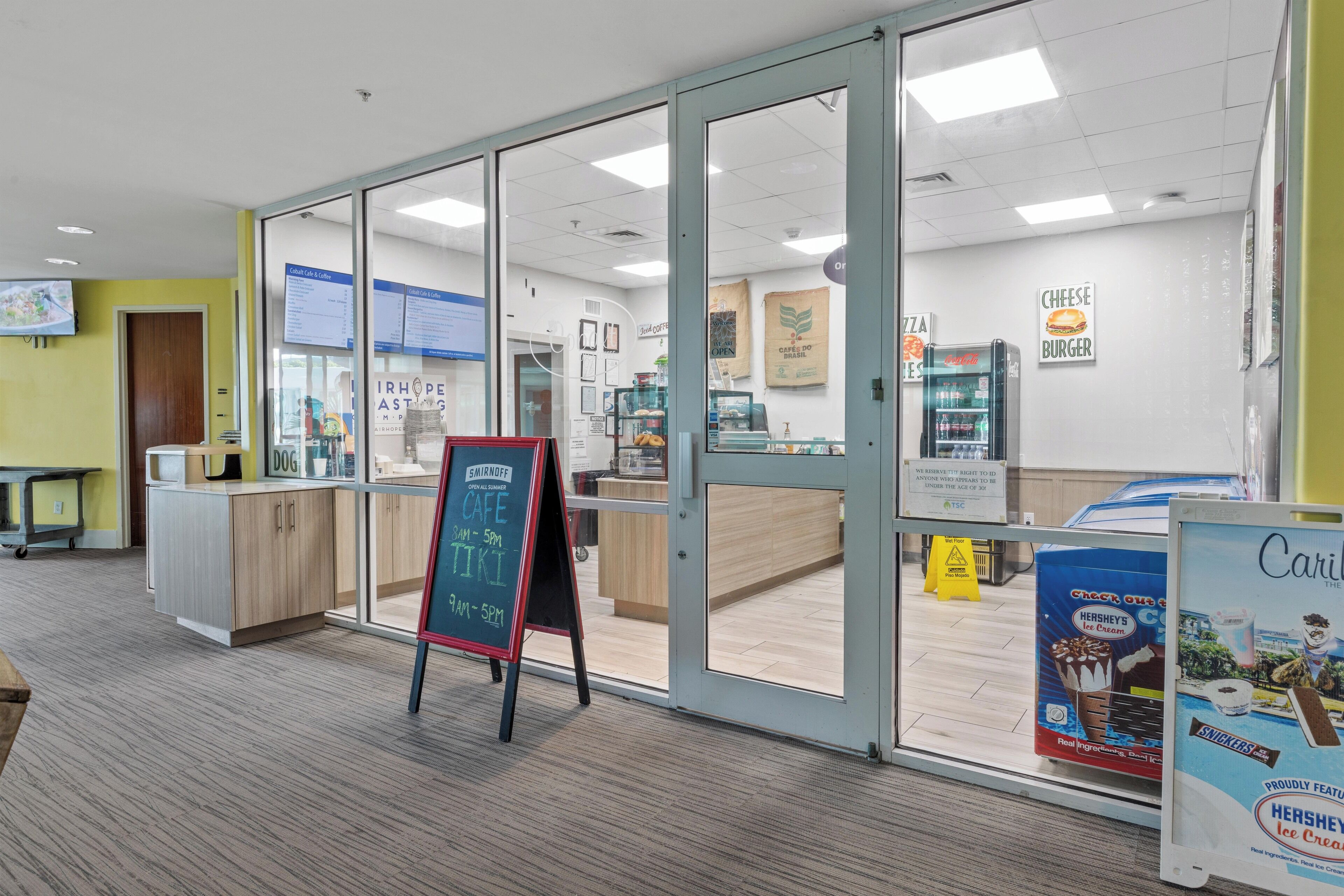 A cafe with a glass door, a chalkboard menu, and a sign for Hershey's ice cream.