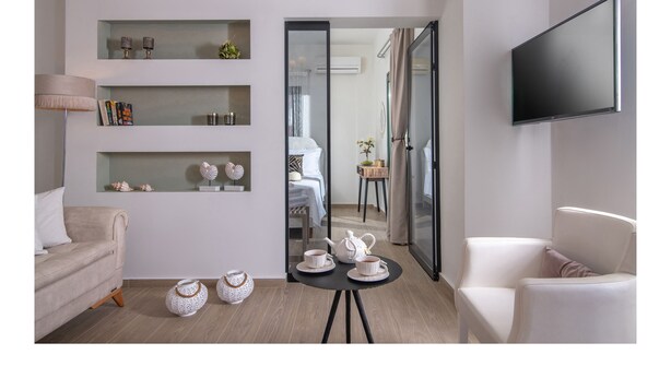 Una sala de estar moderna con un sofá, una mesa de centro y un televisor montado en la pared.
