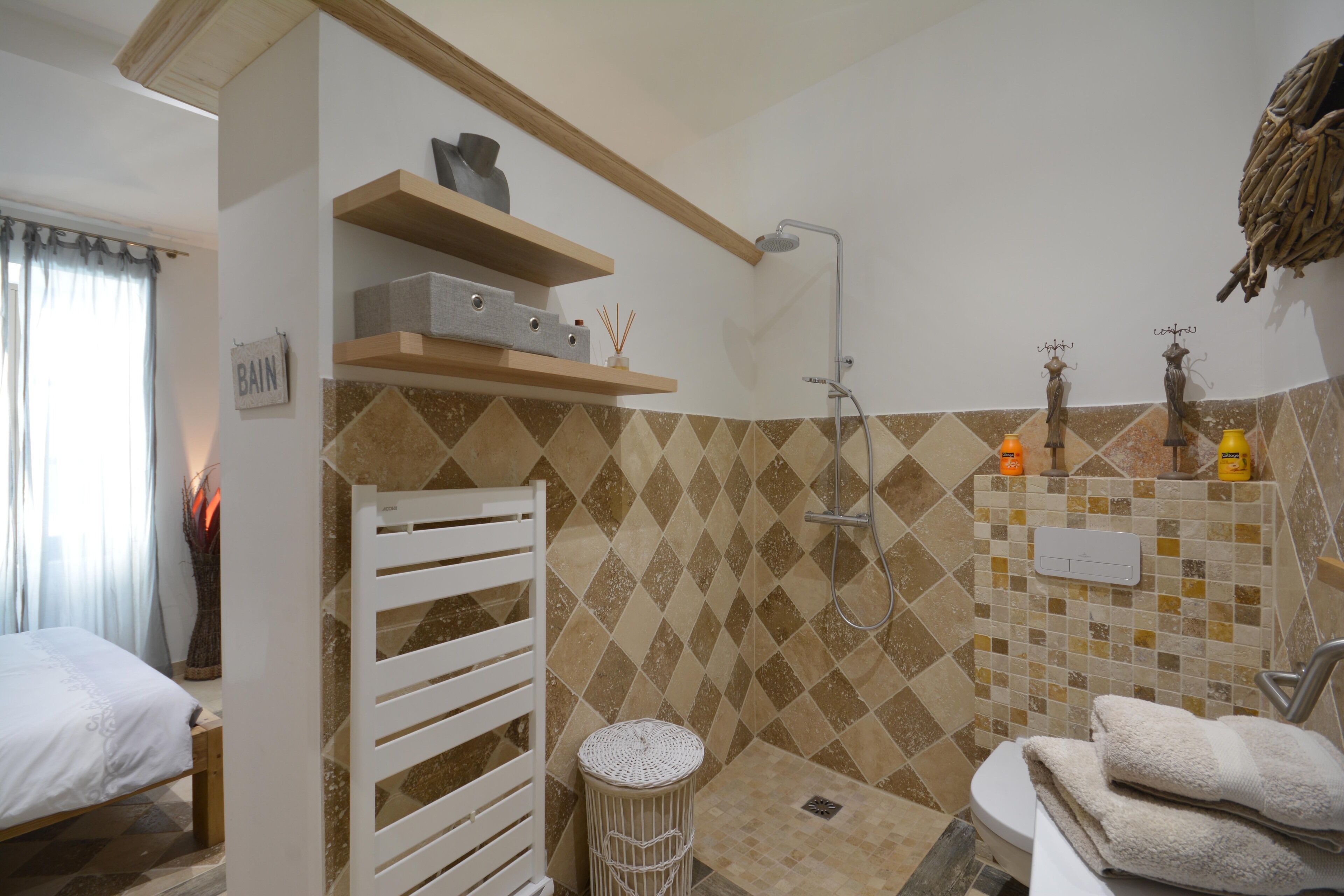 A bathroom with a shower, toilet, and a bed.