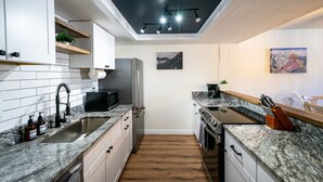 Een moderne keuken met witte kasten, een dakraam en een centraal eiland.