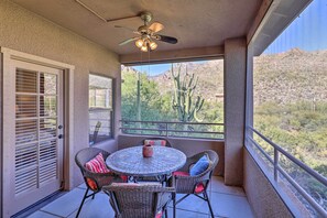 Relax in style on this covered patio with a round table and comfortable wicker chairs.