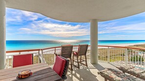 A balcony with a view of the ocean, wooden furniture, and a pool area. - Your PooleParadise (Navarre Beach)