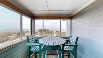 Enjoy breathtaking views of the beach and dunes from this room's expansive windows.