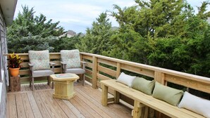 A wooden deck with a bench and chairs, surrounded by greenery. - SALVO STARRY NIGHTS Beach House Bliss 5 min walk to beach (Salvo)