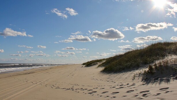 A beach with footprints leading to dunes and the ocean. - SALVO STARRY NIGHTS Beach House Bliss 5 min walk to beach (Salvo)