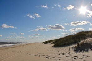 A beach with footprints leading to dunes and the ocean. - SALVO STARRY NIGHTS Beach House Bliss 5 min walk to beach (Salvo)