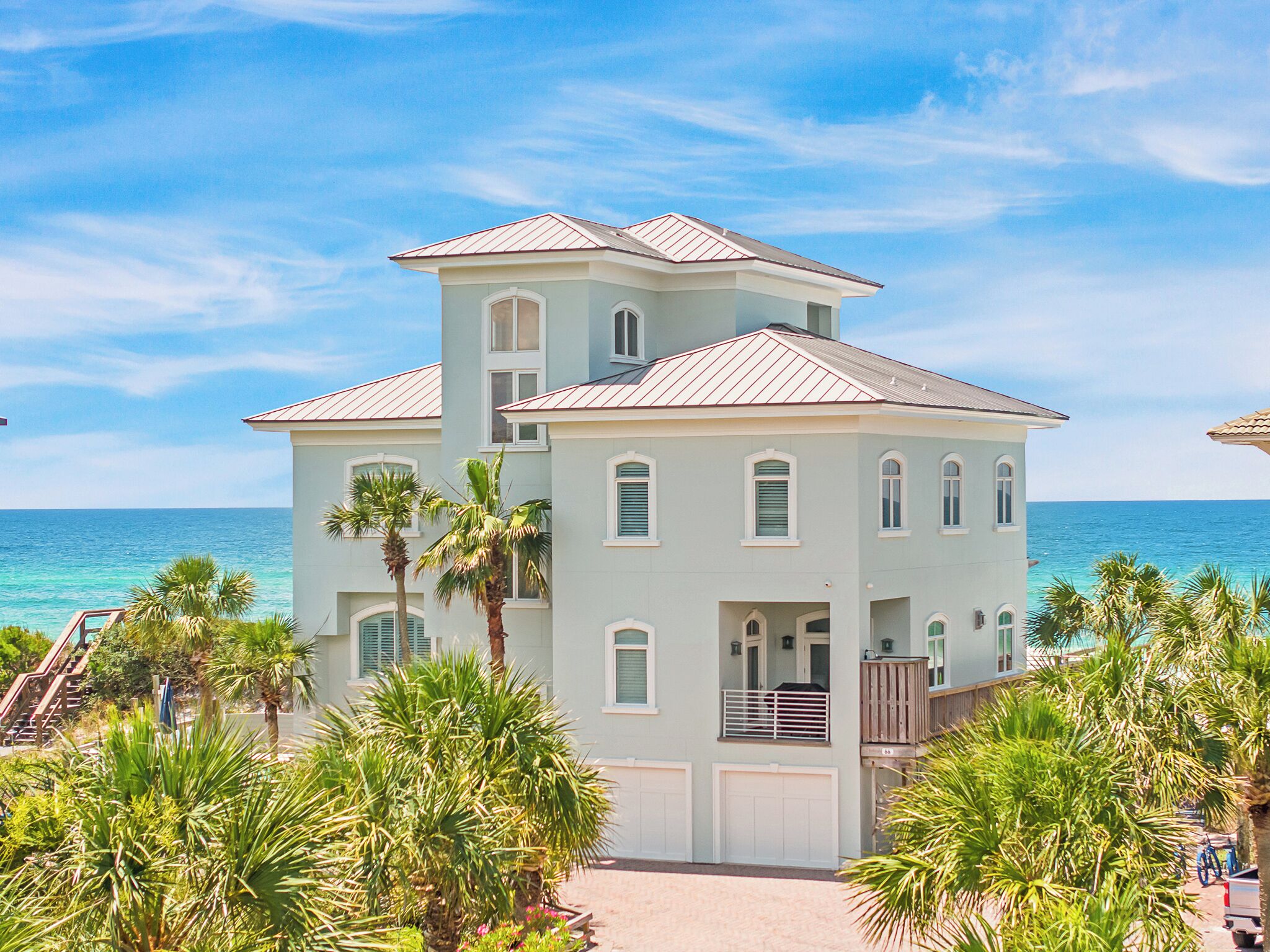 Il s’agit d’un immeuble à plusieurs étages situé en bord de mer, avec une façade bleu clair, de nombreuses fenêtres et un balcon.