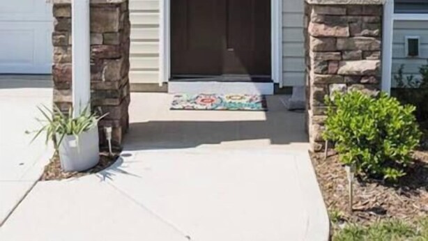 A two-story house with a front porch, a dark brown door, and a stone pillar on each side. - Room for Everyone with 2 Townhomes and 6 Bedrooms! (Candler)