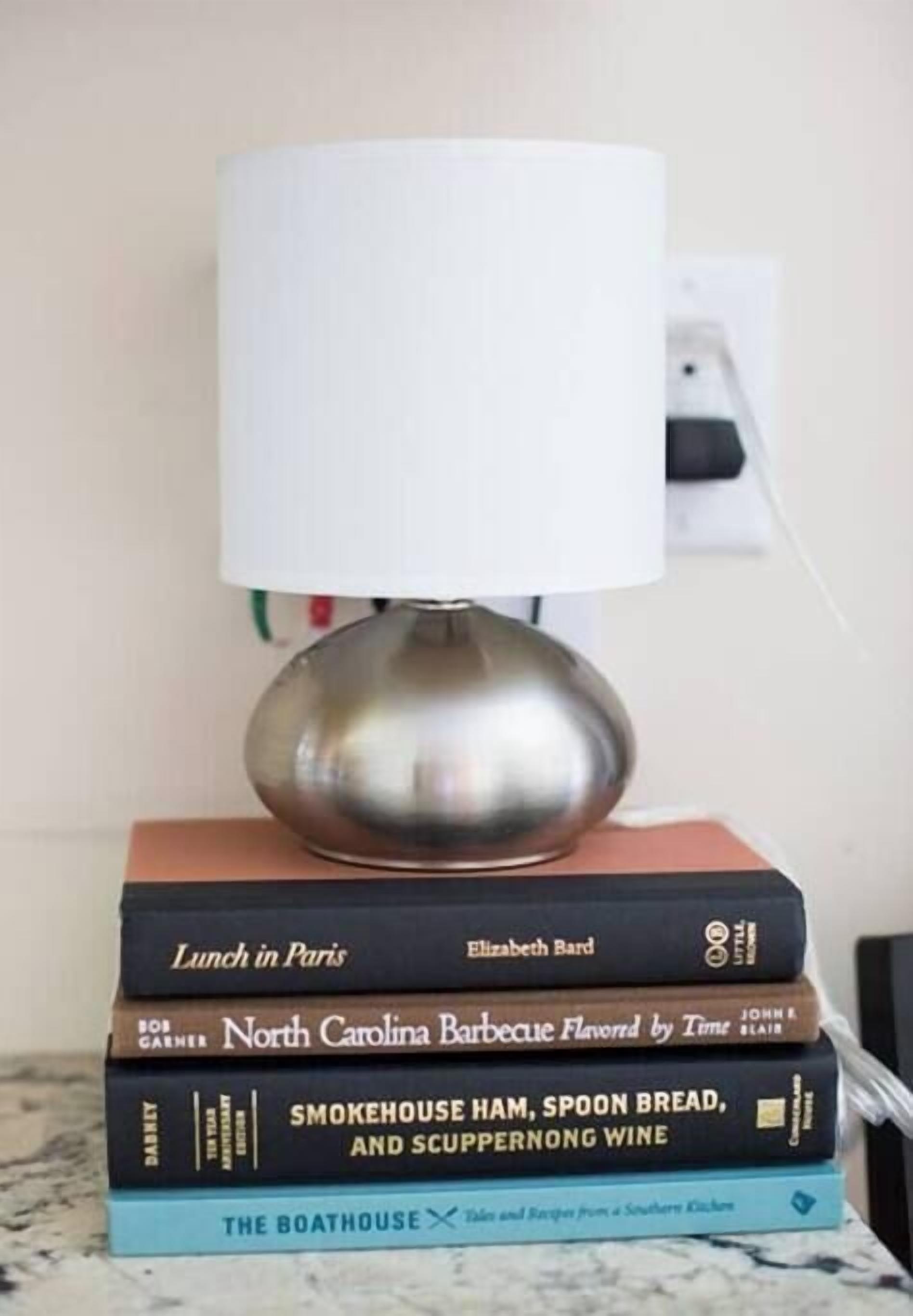 Ein Stapel Bücher mit einer Lampe darauf.