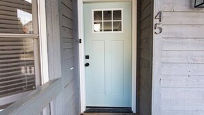 A light blue front door with a small window above it, a black doormat, and a house number '45' on the right side. - *Comfy Smart Condo|10 mins to DT & (Asheville)