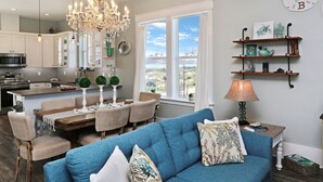 Una cucina moderna con zona pranzo, un divano blu e un lampadario.