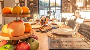 Una mesa de madera con una variedad de frutas, pasteles y café para el desayuno.