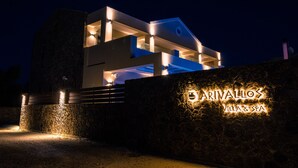 Una villa moderna con fachada de piedra y letreros iluminados que dicen 'ARIVALLOS VILLA & SPA'.