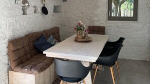 Ein gemütlicher Essbereich mit einem Holztisch, schwarzen Stühlen und einem braunen Sofa.