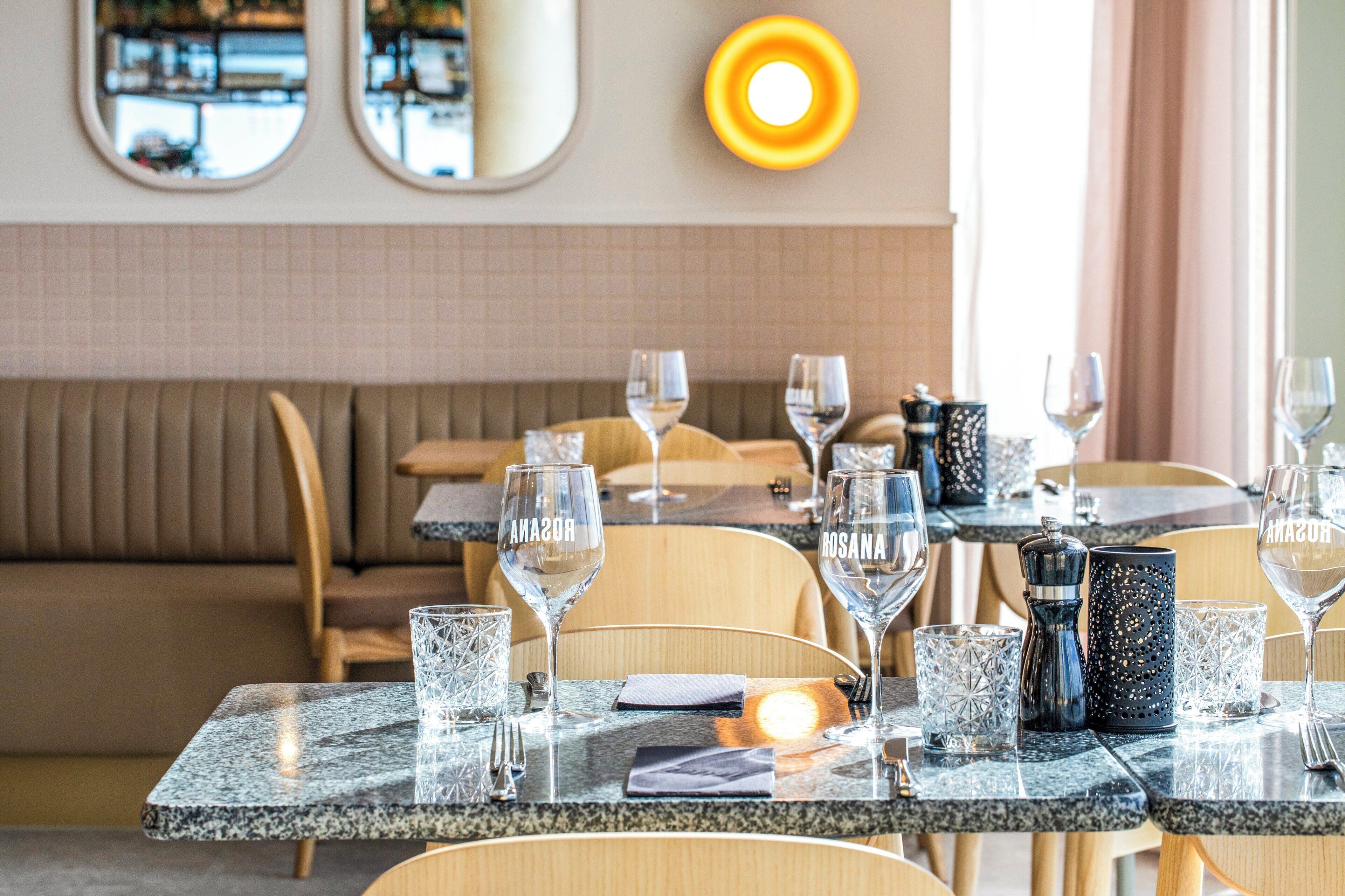 A restaurant with marble tables, clear glasses, and a modern interior design.