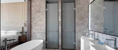 Un baño moderno con una bañera independiente, un espejo grande y un lavabo doble.