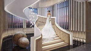 Ein modernes Interieur mit einer geschwungenen Treppe, spiegelndem Boden und dekorativen Kugeln.