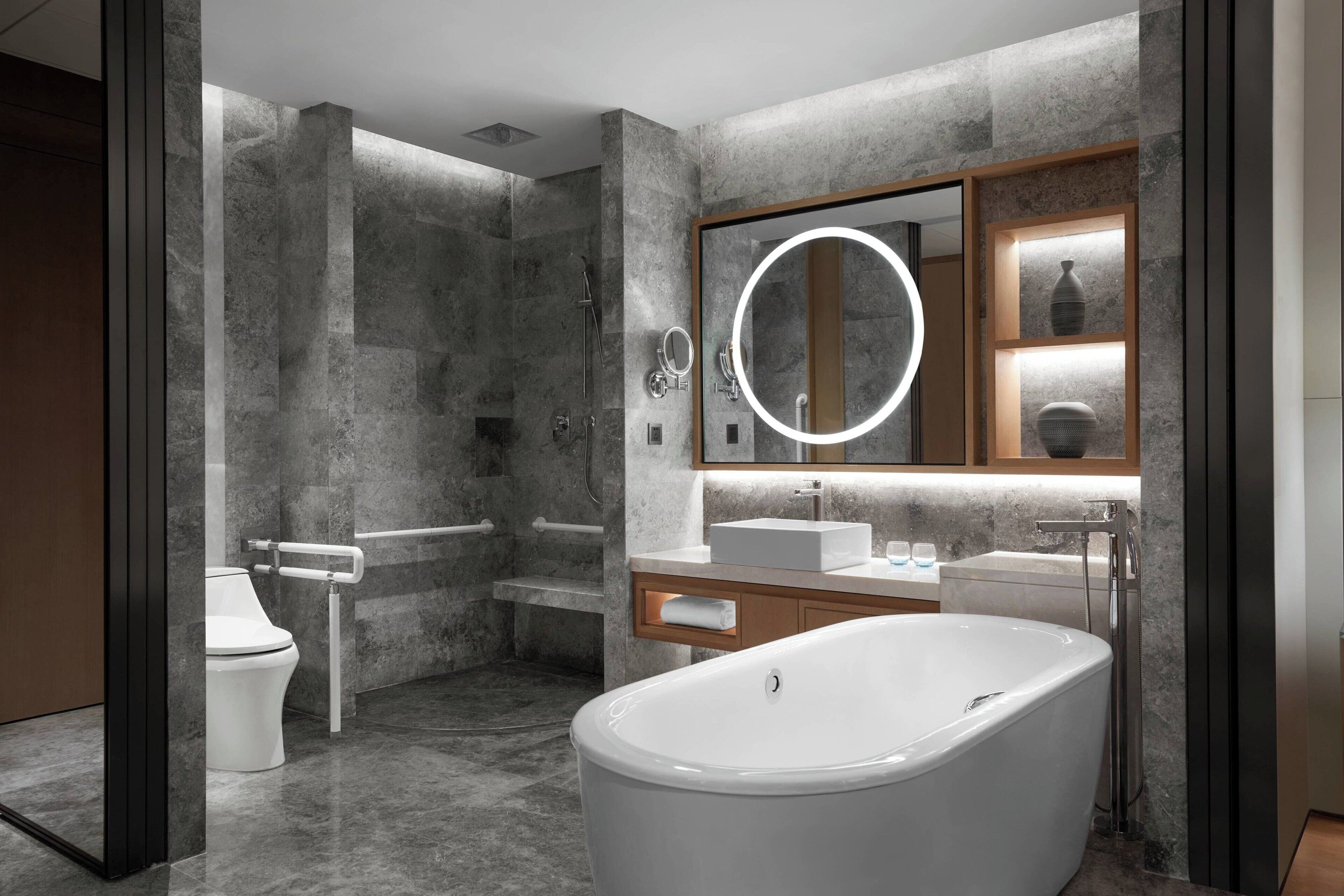 Une salle de bain moderne avec une baignoire sur pieds, un meuble-lavabo avec un miroir et des toilettes.