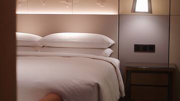 A neatly arranged bedroom with a bed, bedside table, and a bench.