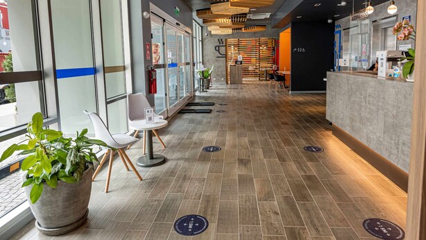 A modern hotel lobby with a reception desk, seating area, and large windows. - ibis Budget Lima Miraflores (Lima)