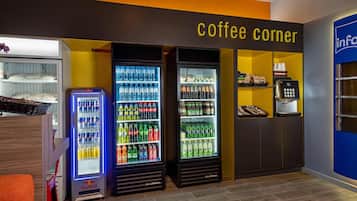 Ein Kaffee-Bereich mit Getränkeautomaten und einer Red Bull Kühlbox sowie einer Kaffeemaschine.