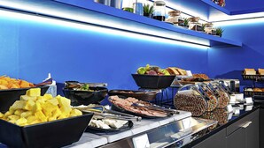 A buffet with various food items and a blue wall in the background. - ibis Budget Lima Miraflores (Lima)
