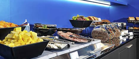 Un buffet proposant une variété de plats, avec un mur bleu en arrière-plan.
