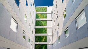 A modern building with a central atrium, multiple windows, and a patterned floor. - ibis Budget Lima Miraflores (Lima)