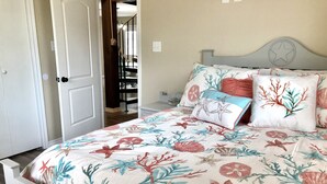 Une chambre à coucher avec un lit, une table de chevet et une porte donnant sur un escalier.