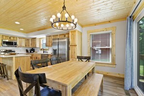 Una cocina amplia con armarios de madera, una isla central y un comedor con bancos.