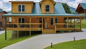 A two-story log cabin with a porch and a metal roof. - New Log Cabin in the Valley, Elk Experience, Year Round Access (Maggie Valley)