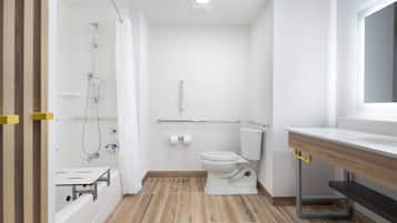 A modern bathroom with a shower, toilet, and sink.