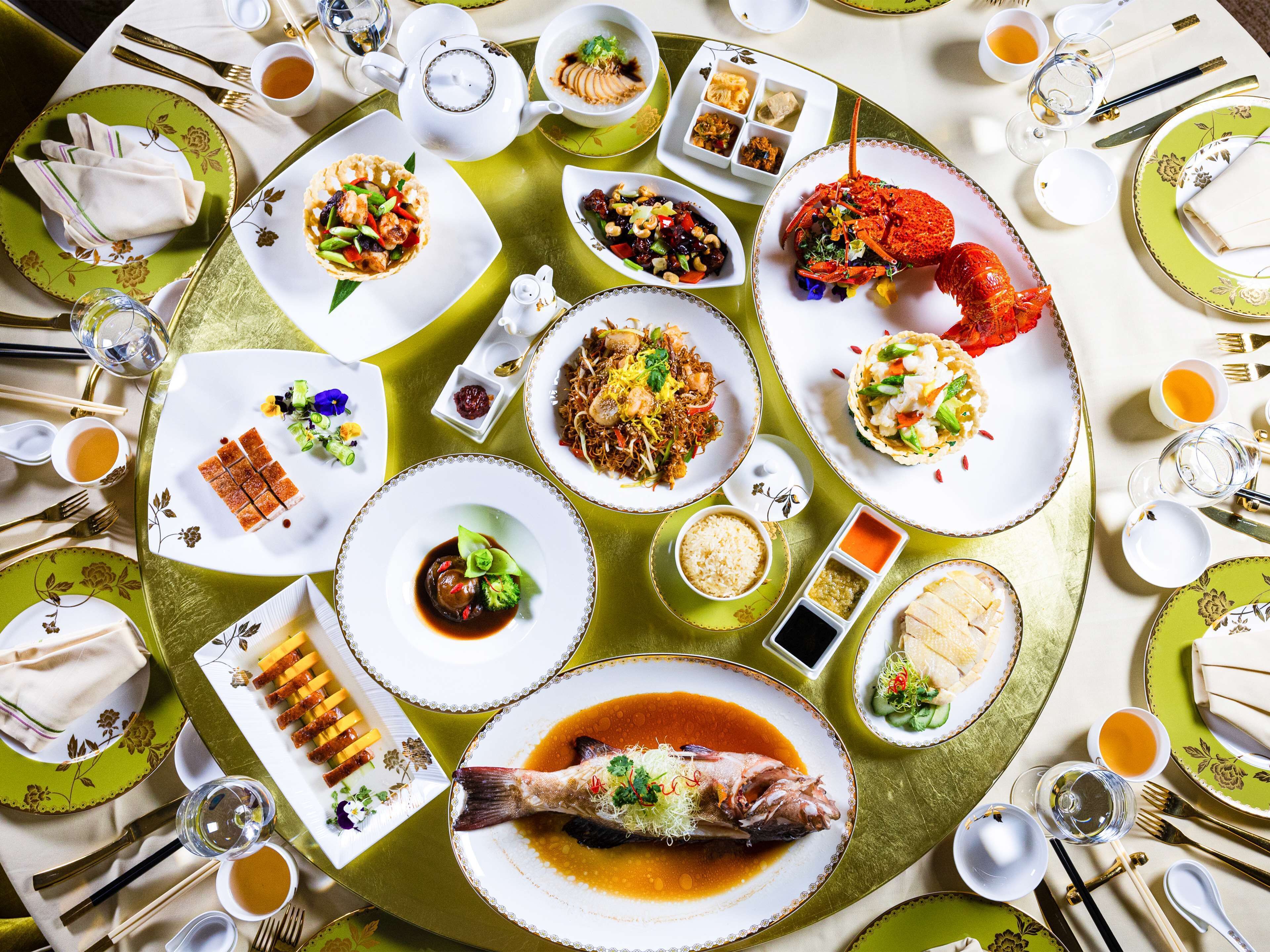 A round dining table with various dishes and utensils.