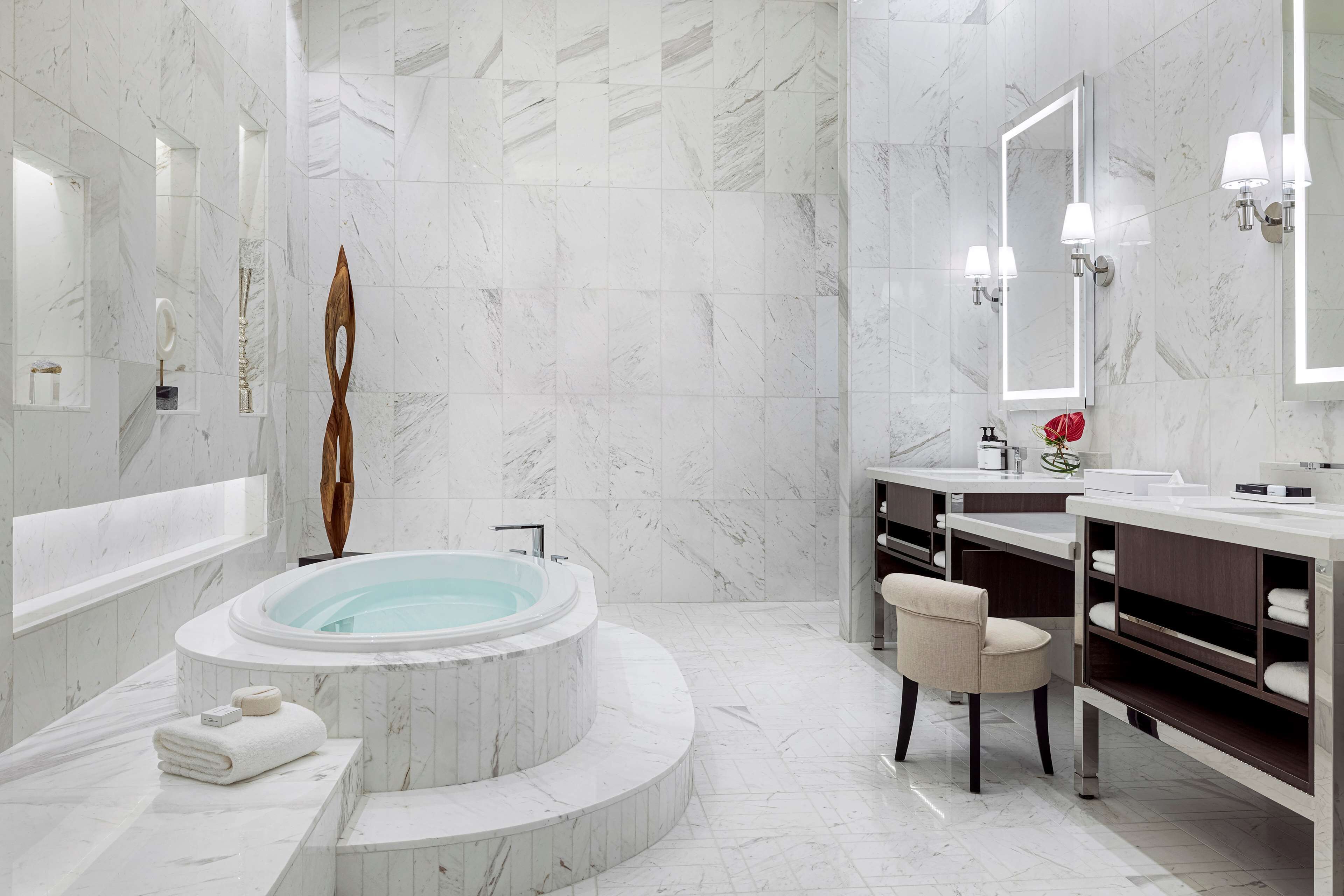 Un baño moderno con una bañera independiente, un tocador con espejo y un perchero para toallas.