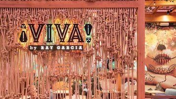 Una pérgola de madera con un letrero decorativo que dice "VIVA by Ray Garcia".