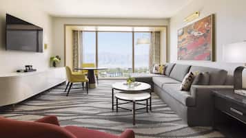 A modern living room with a sofa, a coffee table, and a TV mounted on the wall.
