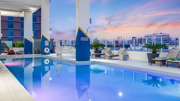 A rooftop pool with a cityscape view, lounge chairs, and a 'NO DIVING' sign. - SERENA Hotel Aventura Miami, Tapestry Collection by Hilton (Aventura)