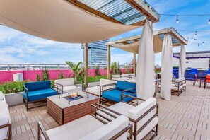 A rooftop lounge with outdoor seating, a fire pit, and a view of the city skyline. - SERENA Hotel Aventura Miami, Tapestry Collection by Hilton (Aventura)