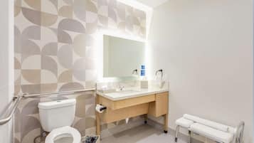 A modern bathroom with a toilet, sink, and bench.
