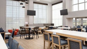 A modern dining area with high tables, bar stools, and comfortable seating.