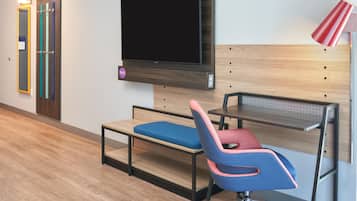 Un espacio de oficina moderno con un escritorio, una silla y un televisor de pantalla plana montado.