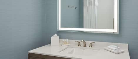 Een moderne badkamer met een grote spiegel, twee wastafels en een badkamermeubel met lades.