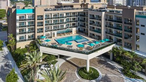 Ein modernes Hotel mit Dachpool, mehreren Balkonen und einem begrünten Innenhof.
