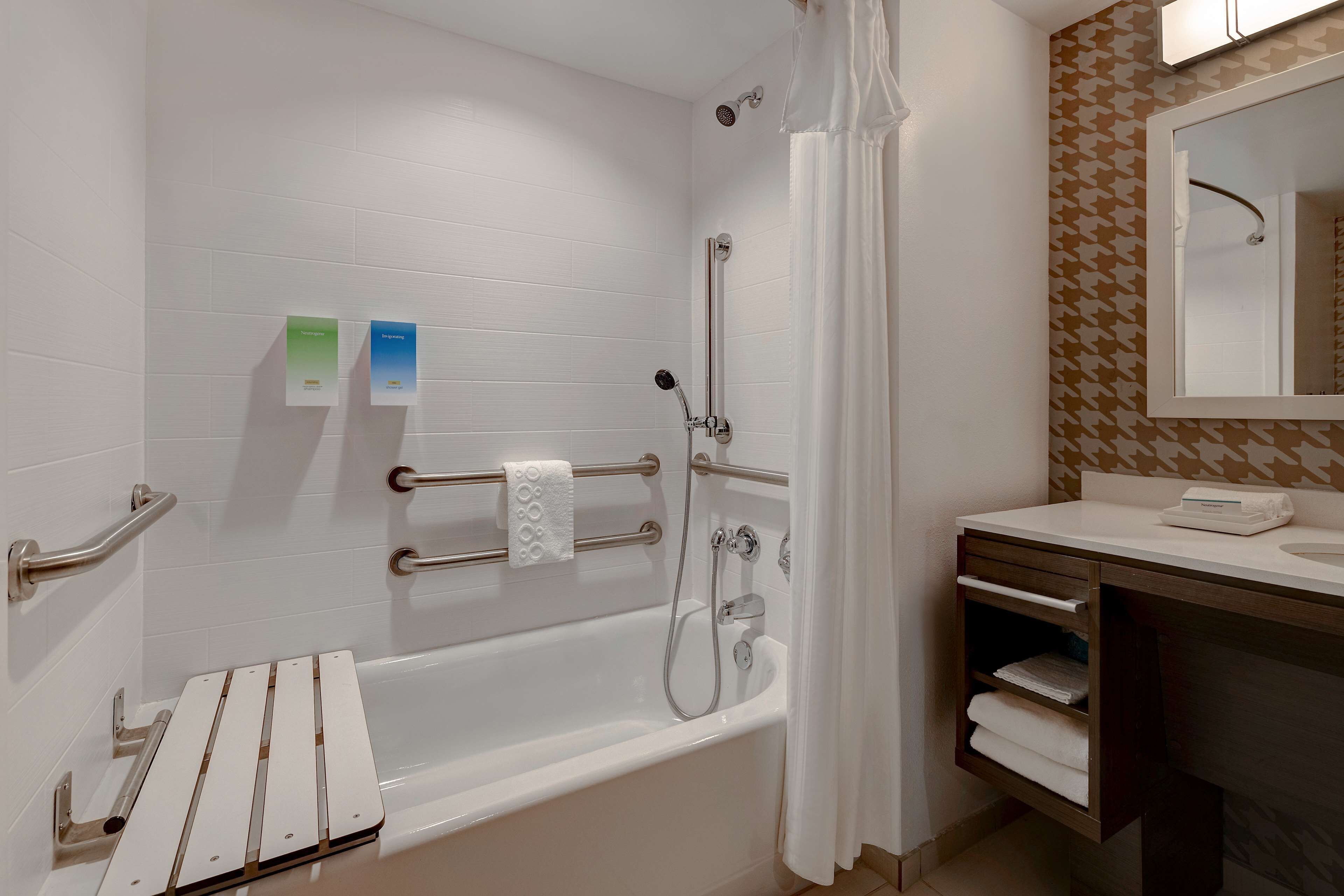 A modern bathroom with a bathtub, shower, and vanity.
