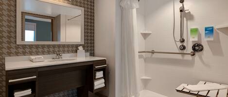 A modern bathroom with a shower, a vanity with a mirror, and a towel rack.