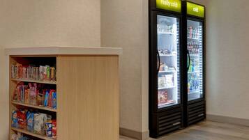 A section of a store with refrigerated display cases and shelves stocked with various food items.