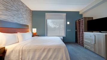 Una habitación de hotel con cama, televisión, escritorio y ventana.