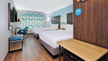 A hotel room with two beds, a desk, a chair, a TV, and a wall with a storage sign.