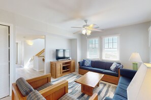 Relax in this stylish living room with a flat-screen TV, comfortable sofa, and wooden coffee table.
