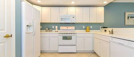 A kitchen with white cabinets, a microwave, a stove, and a dishwasher.